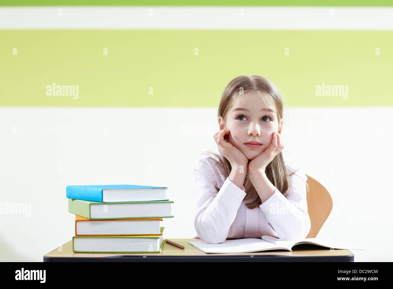a girl sitting at a desk in a classroom Stock Photo - Alamy