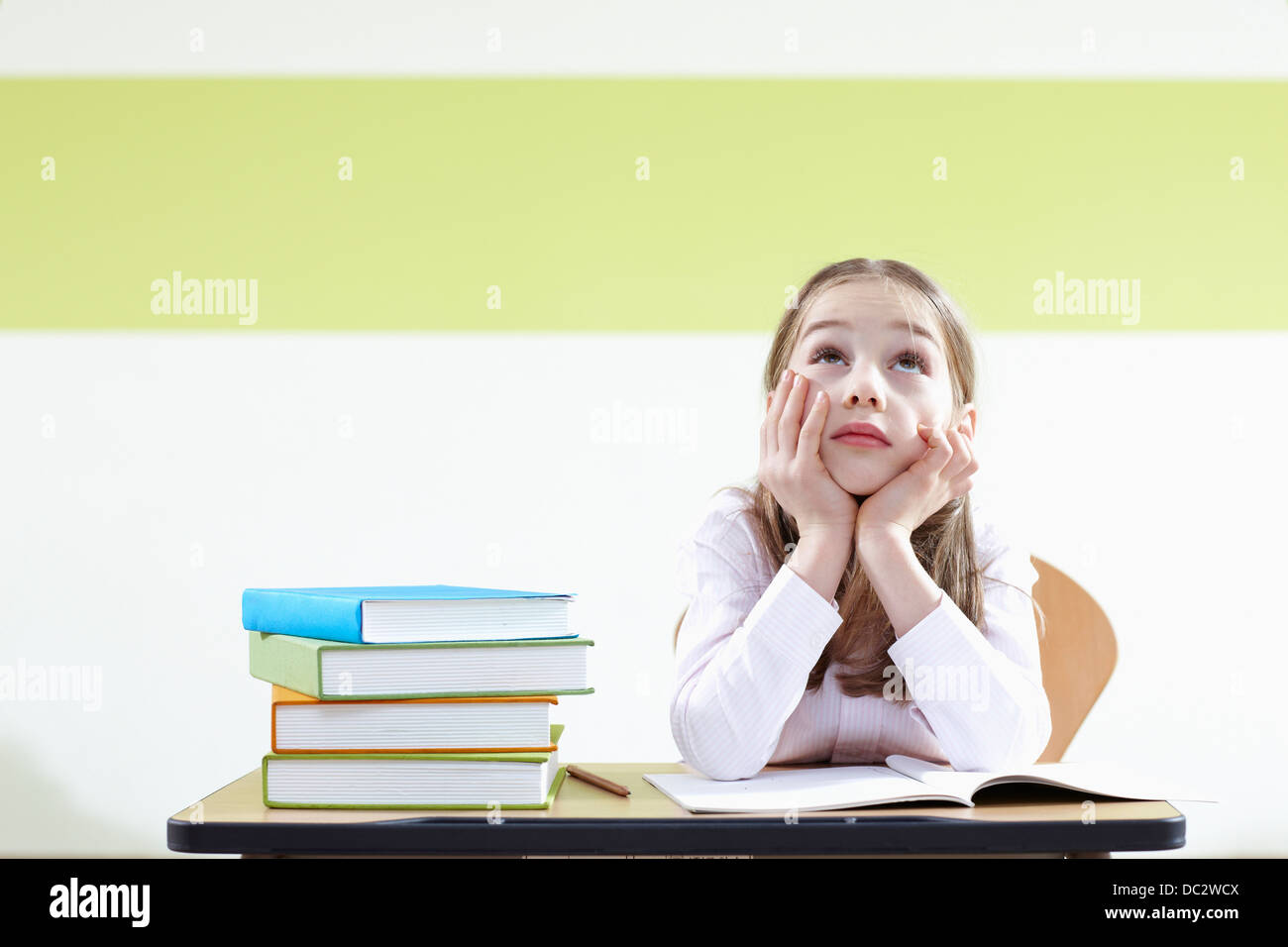 a girl sitting at a desk in a classroom Stock Photo - Alamy