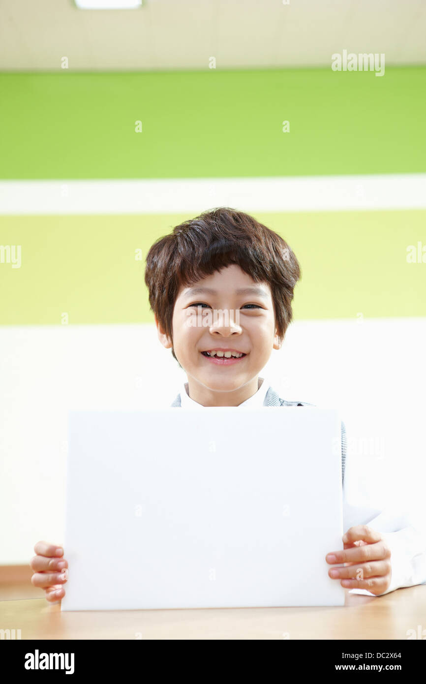 a boy holding an empty white board in a classroom Stock Photo - Alamy