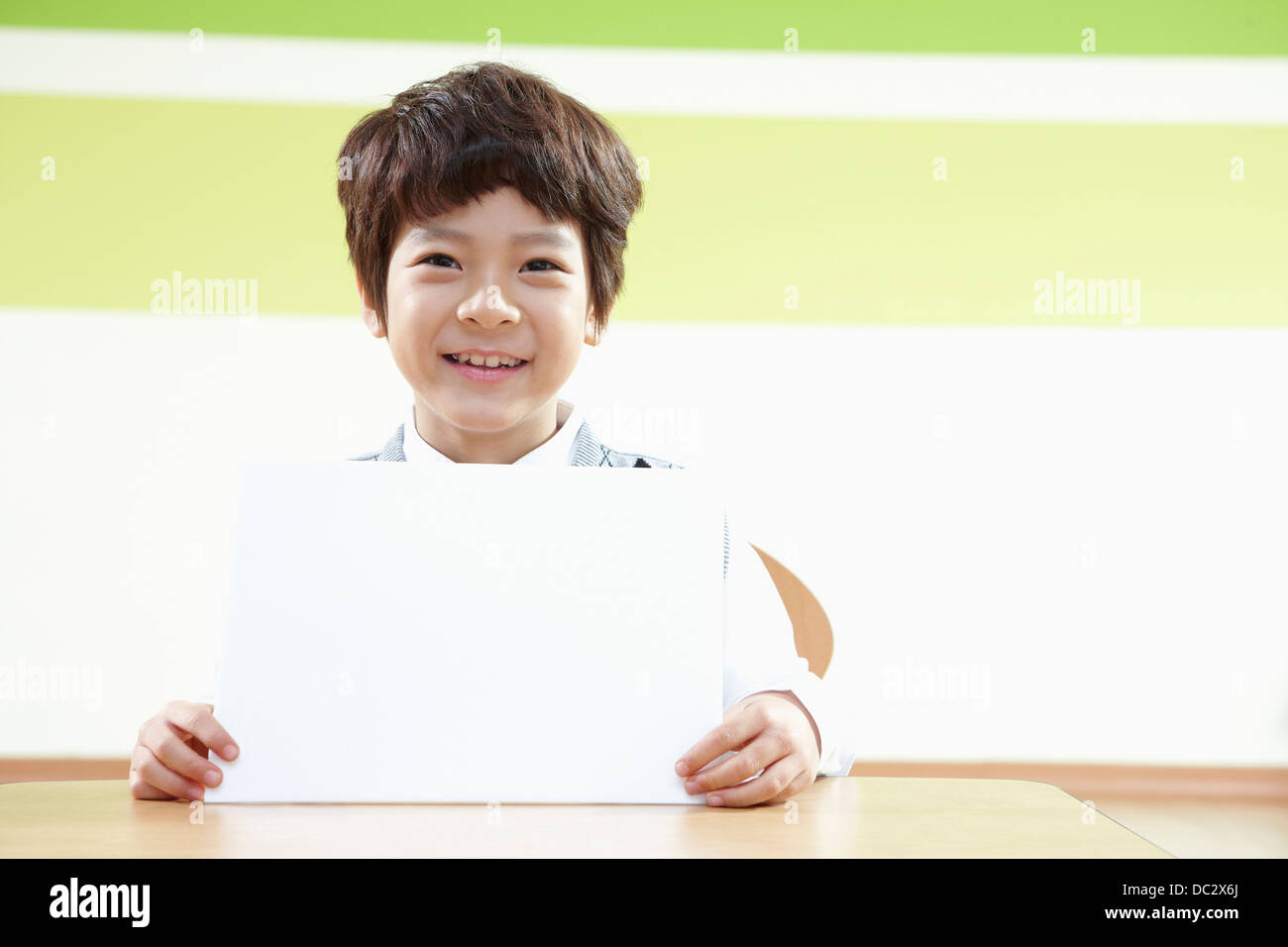 a boy holding an empty white board in a classroom Stock Photo - Alamy