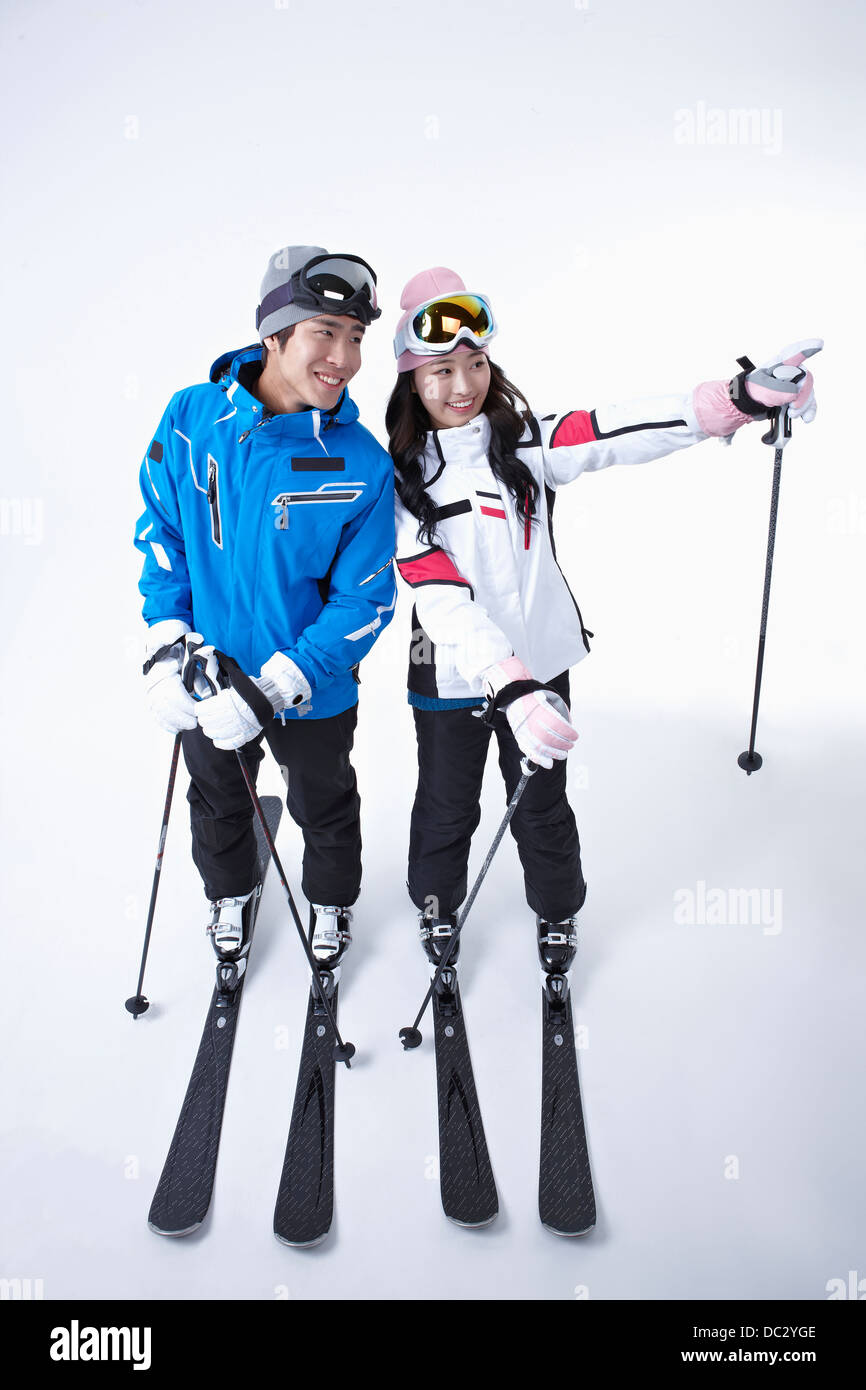 a couple in ski outfit posing in white 