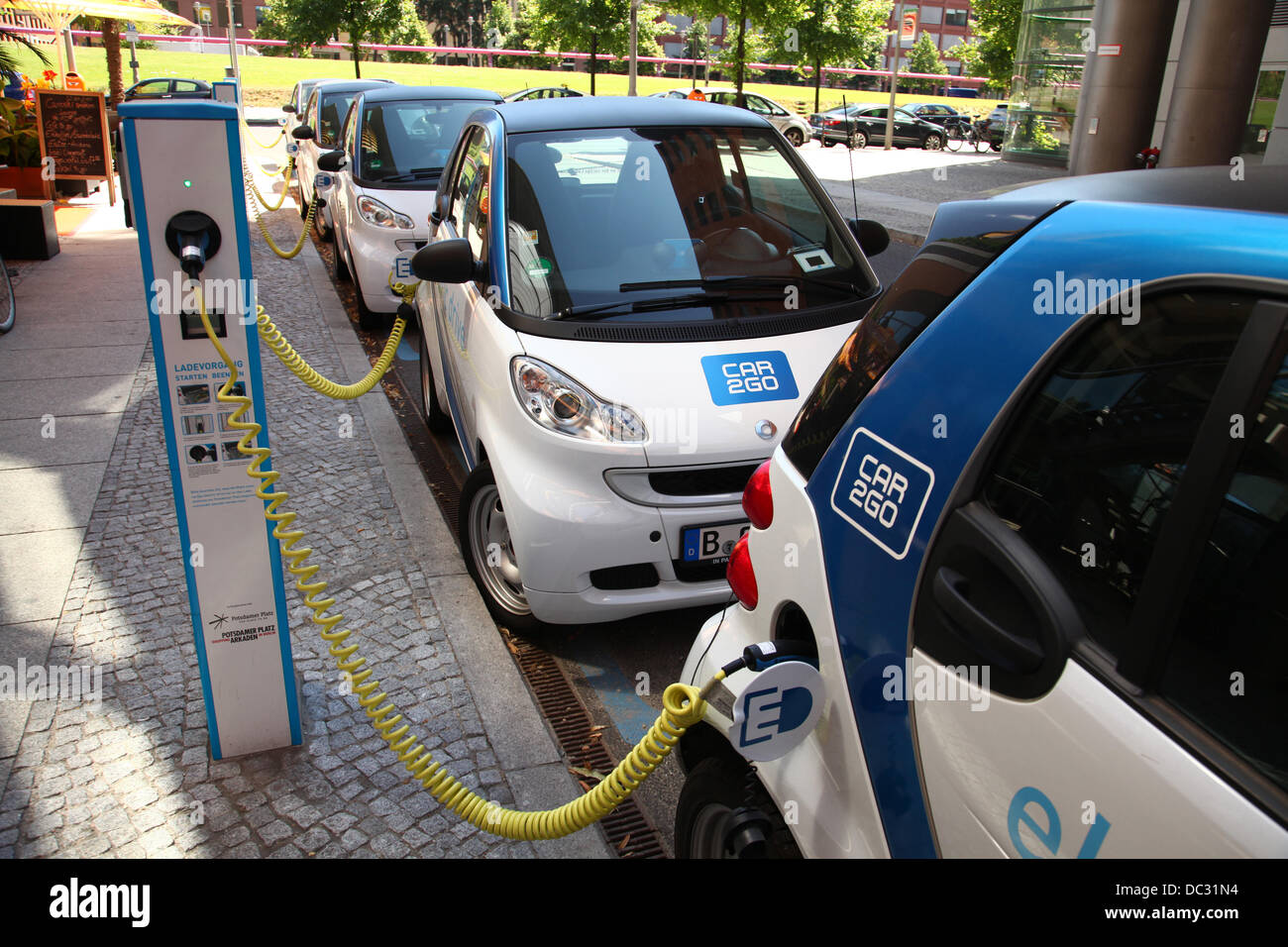 Eectric cars (Smart for two) are parked at a rental and loading station of 'Car2go', which is a carsharing company owned by Daimler in a street in Berlin at Potsdamer Platz (Potsdam square) in July 2013. Photo: Wolfram Steinberg dpa Stock Photo