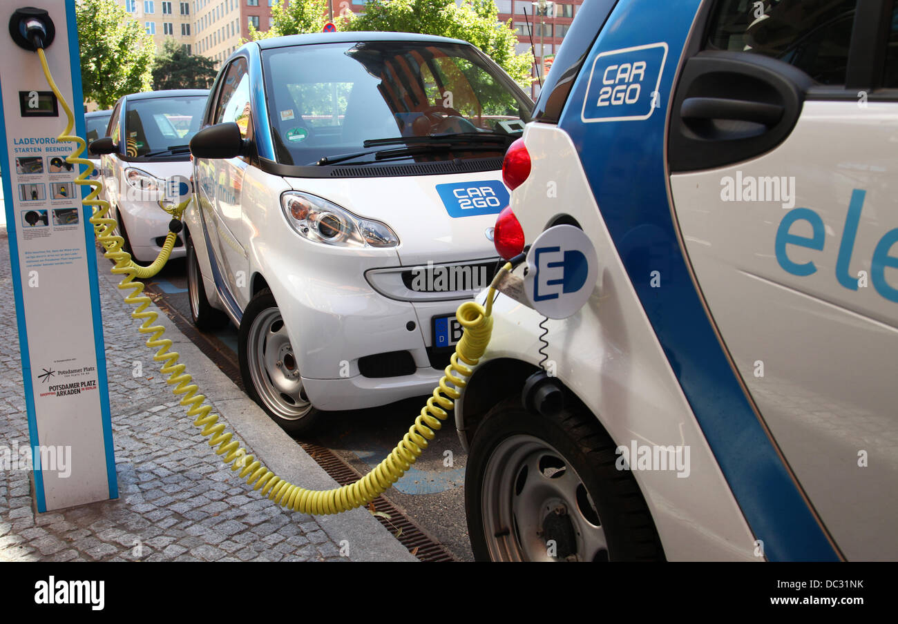 Eectric cars (Smart for two) are parked at a rental and loading station of 'Car2go', which is a carsharing company owned by Daimler in a street in Berlin at Potsdamer Platz (Potsdam square) in July 2013. Photo: Wolfram Steinberg dpa Stock Photo