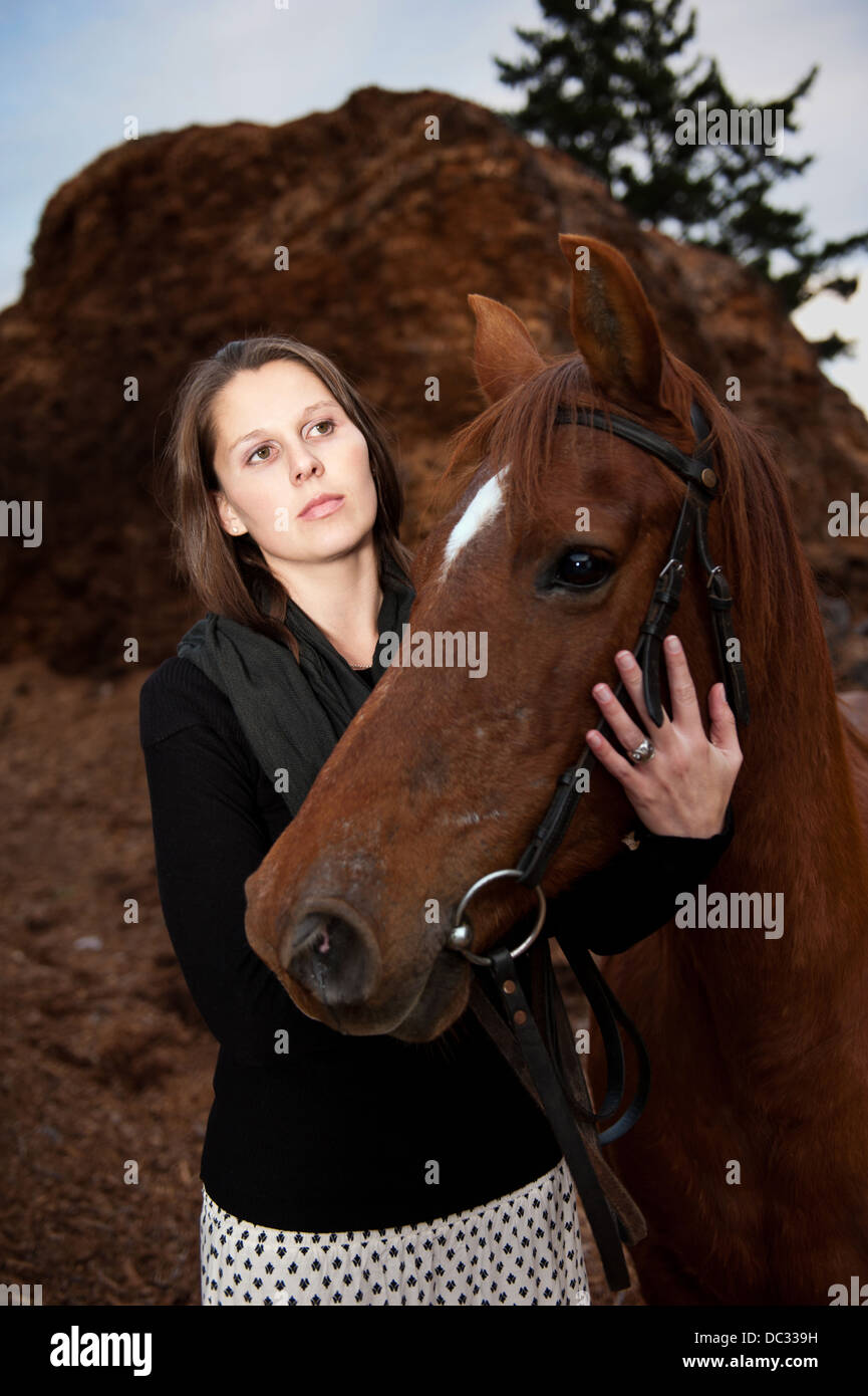 Beautiful young woman with brown Arabian horse. Stock Photo