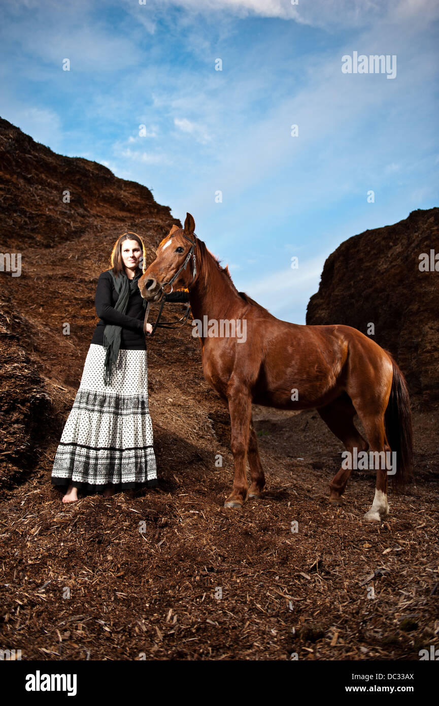 Beautiful young woman with brown Arabian horse. Stock Photo