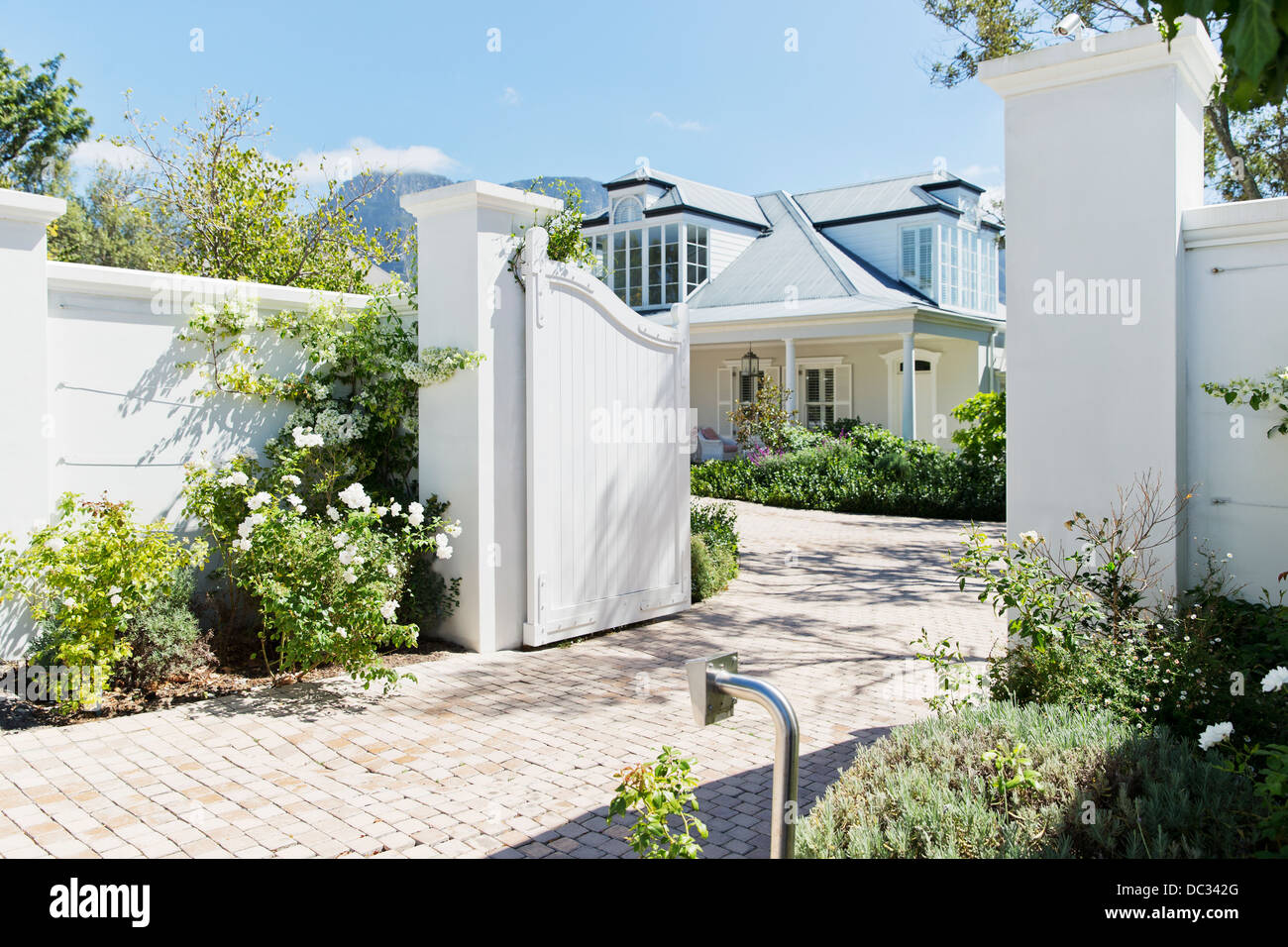 Driveway with open gate to luxury house Stock Photo