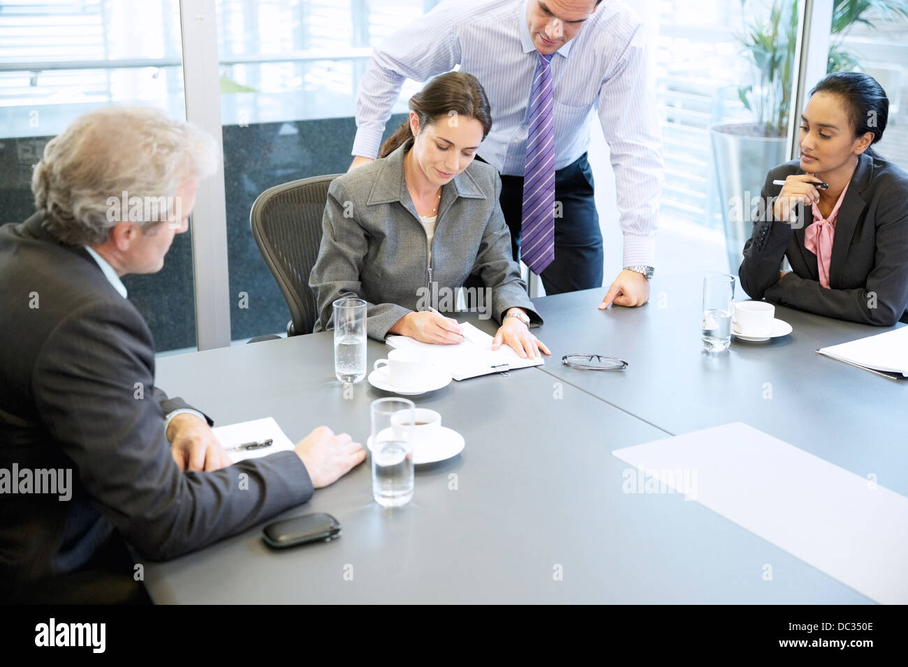 Business people reviewing paperwork in meeting Stock Photo - Alamy