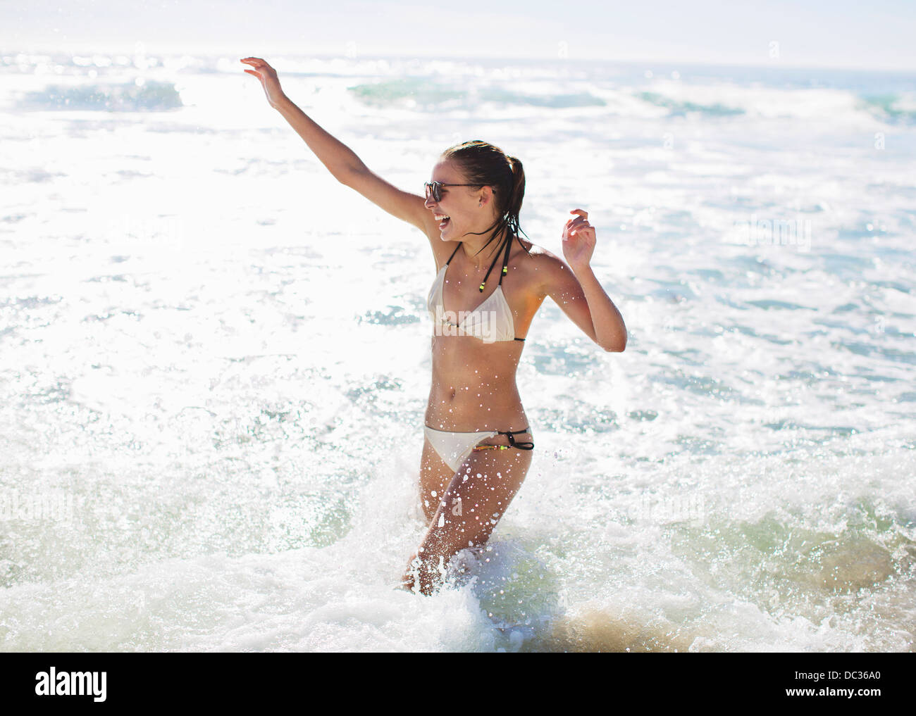 Enthusiastic woman splashing in ocean Stock Photo