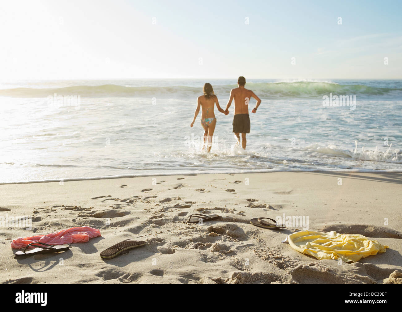 Couple holding hands and wading in ocean Stock Photo