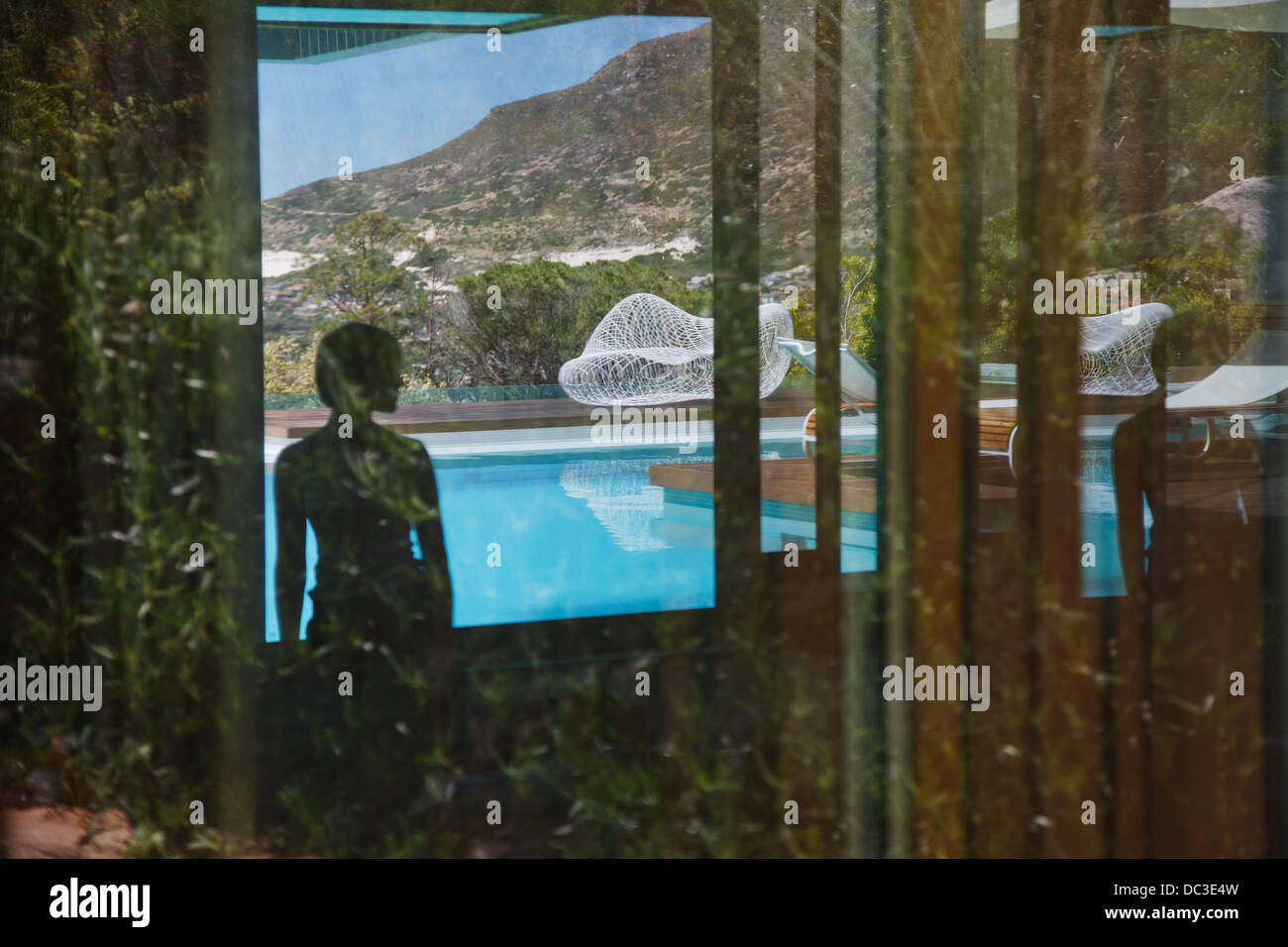 Shadow of woman looking at swimming pool Stock Photo