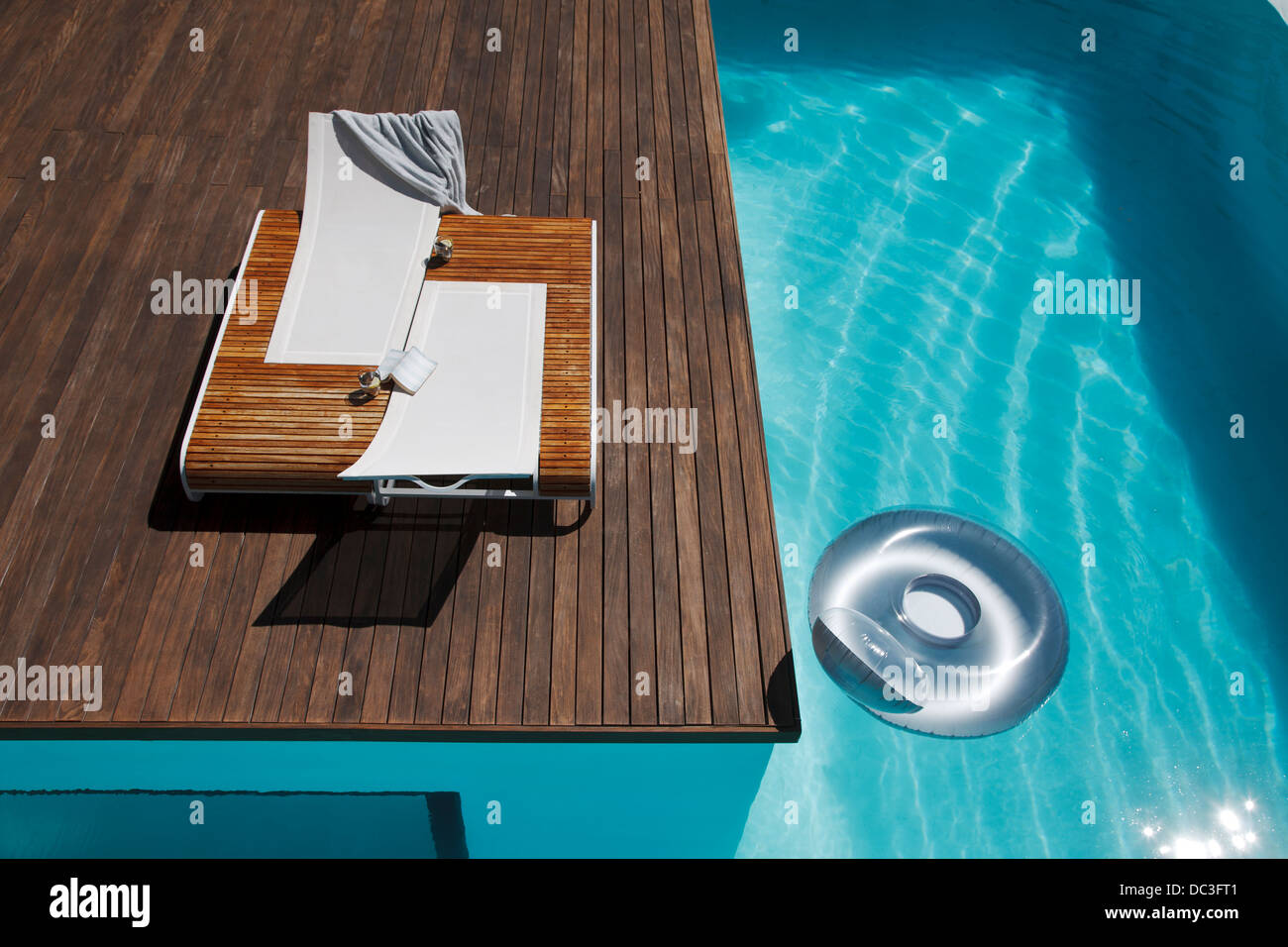 Lounge chairs on deck at luxury poolside Stock Photo