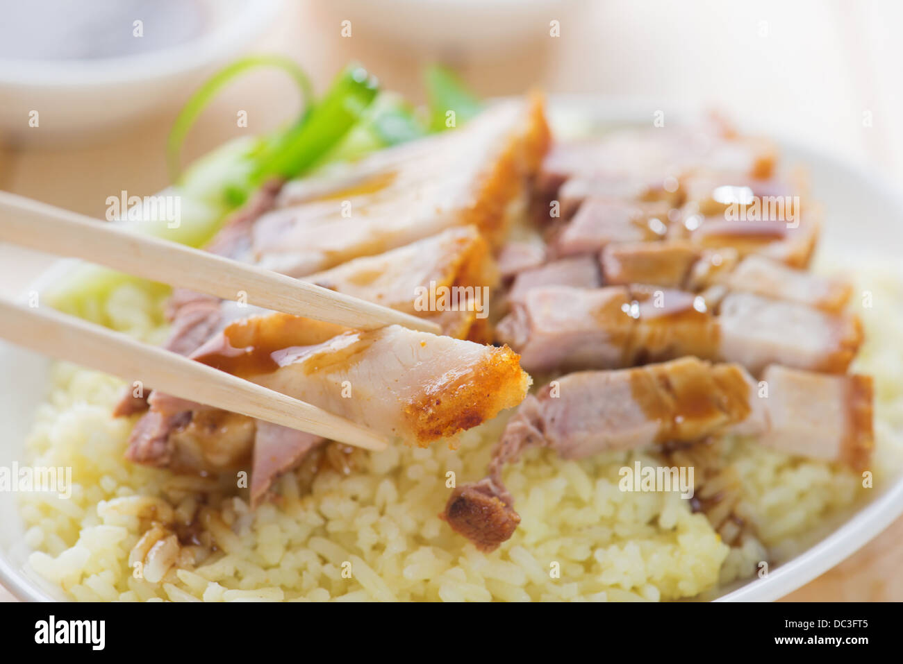 Siu Yuk - Chinese roasted pork served with soy and hoisin sauce. Hong Kong cuisine. Close up on meat and chopsticks. Stock Photo