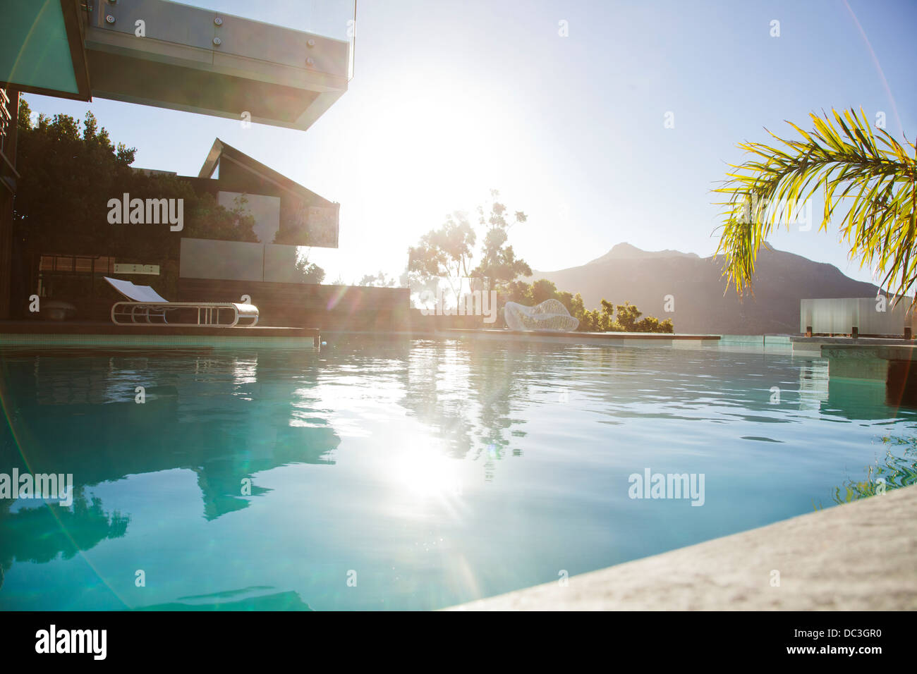 Sun over mountains and swimming pool Stock Photo