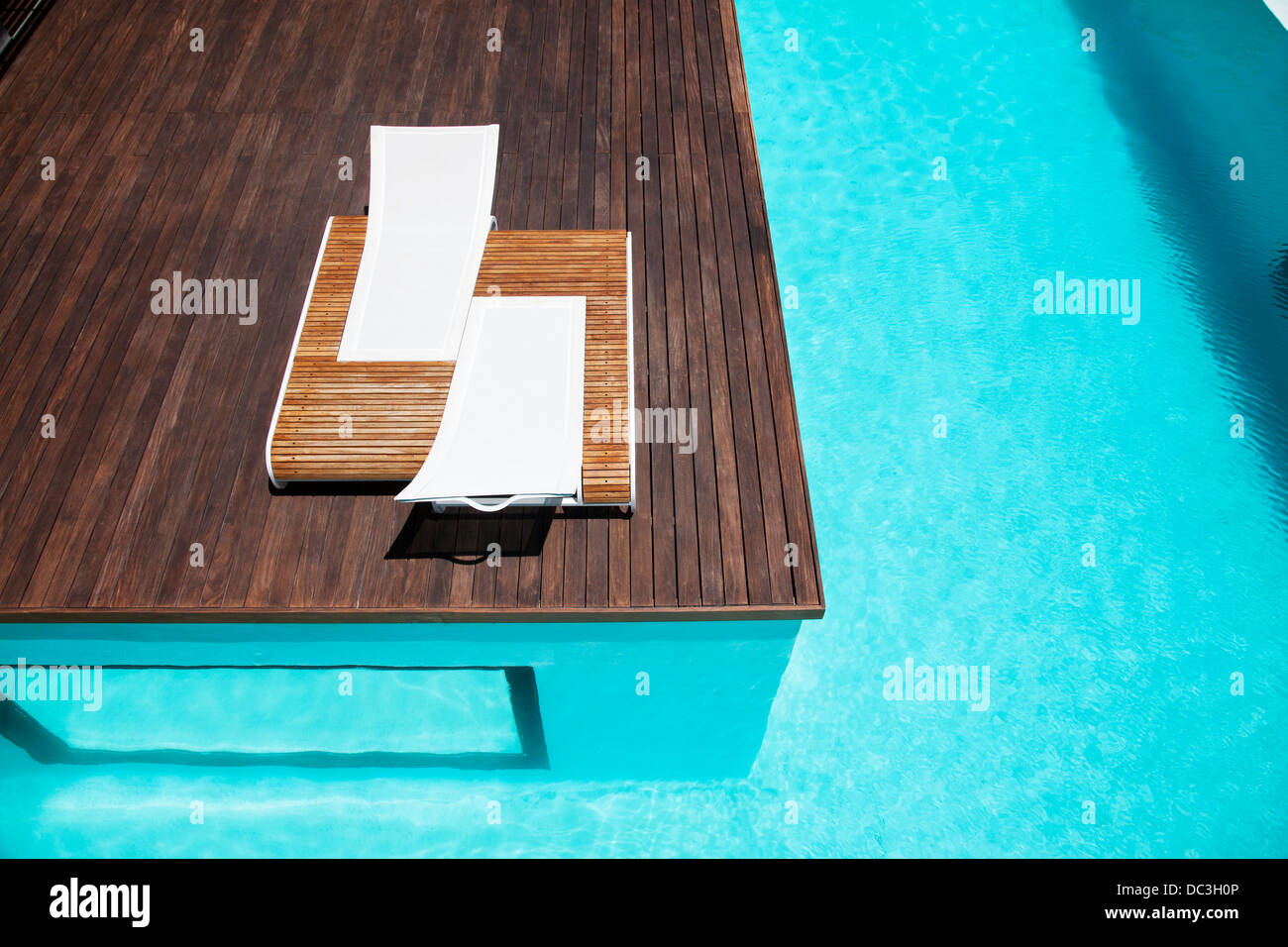 Lounge chairs and swimming pool Stock Photo