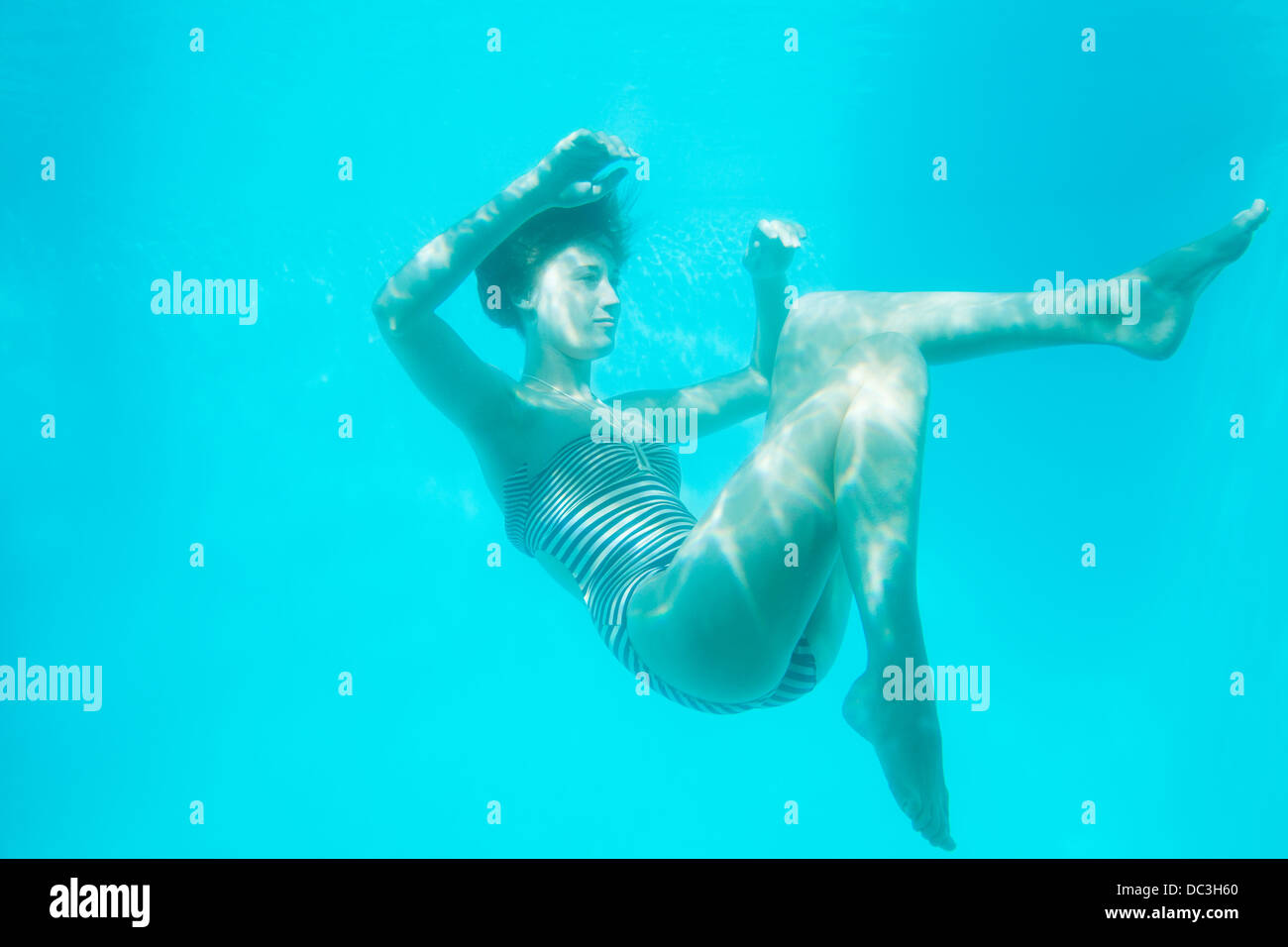 Woman swimming underwater Stock Photo