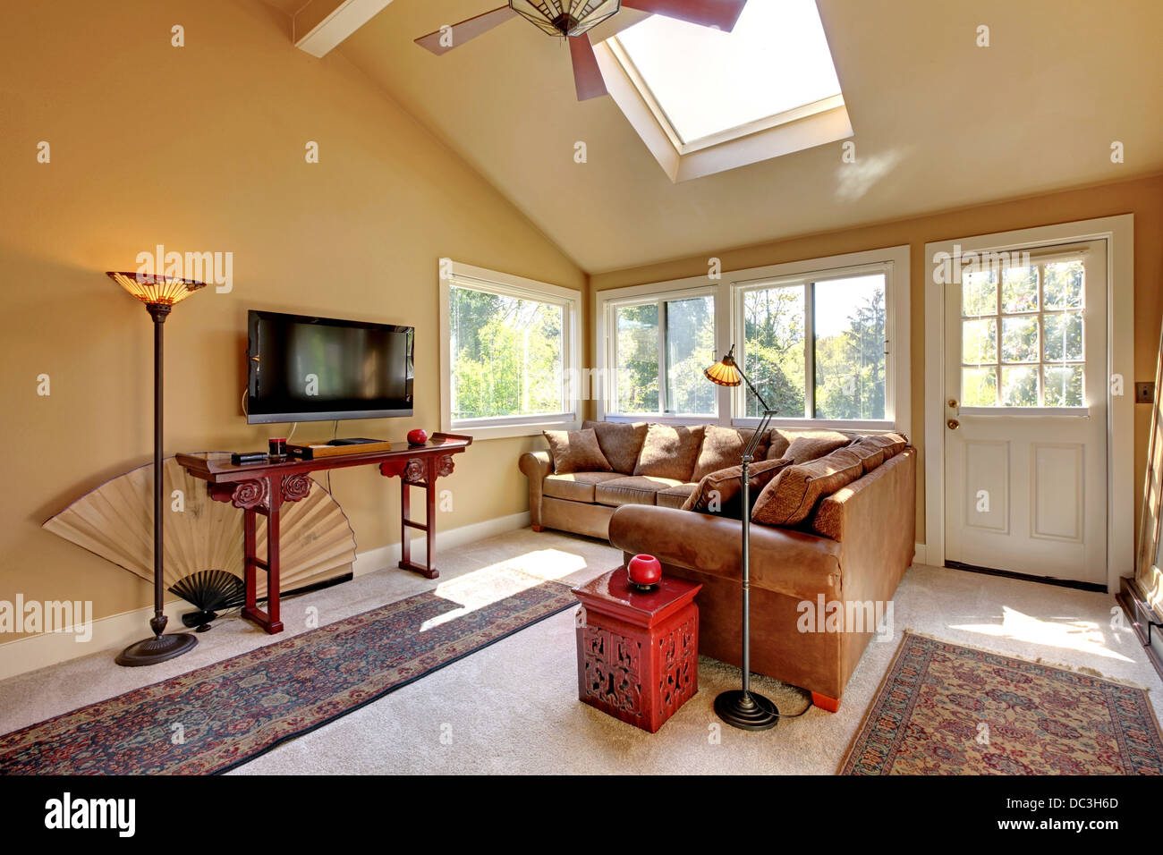 Large living room with sofa, TV and brown walls Stock Photo - Alamy