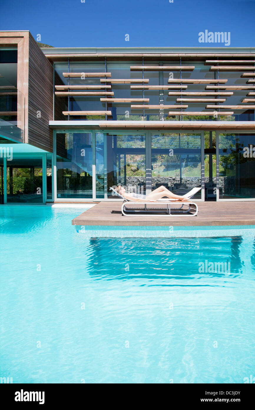 Woman sunbathing on lounge chair at poolside Stock Photo