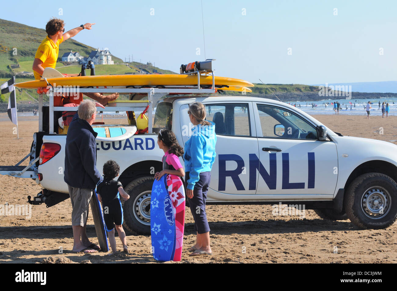 RNLI lifeguard points out the safe area for swimming and surfing