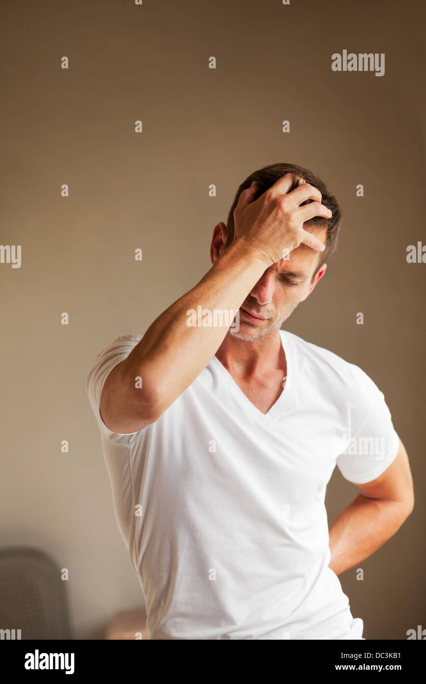 Man holding back and head in pain Stock Photo