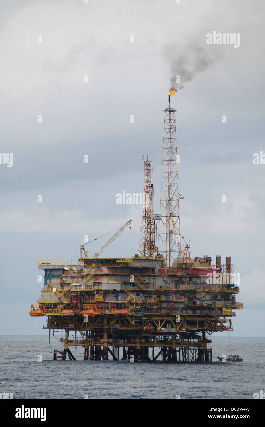 Fishing boat close to offshore oil rig PGP-1 at Campos basin, Rio de Janeiro.  Rig working for Petrobras oil company. Stock Photo