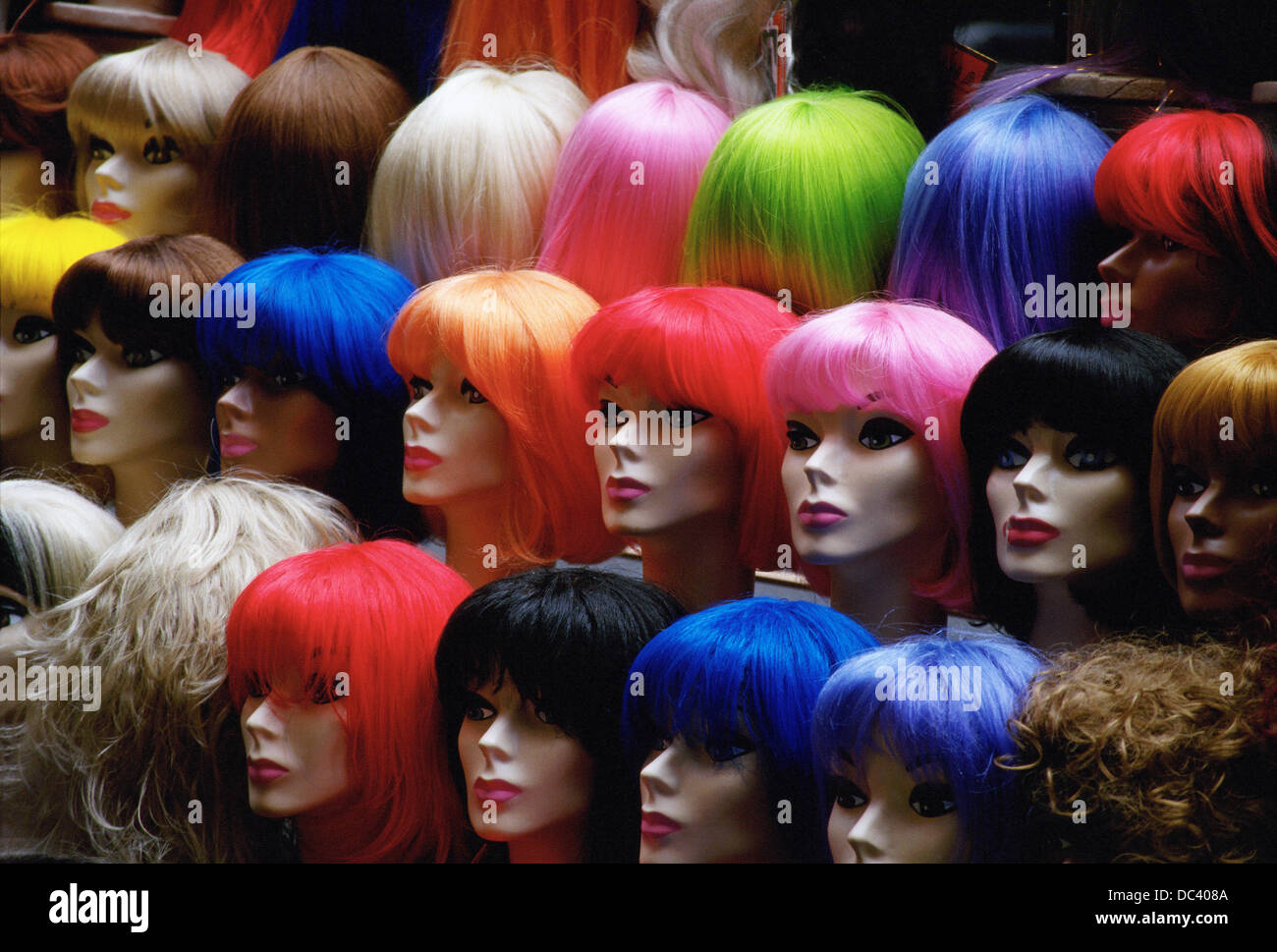 Multi colored wigs on manikin heads displayed in sidewalk street vendor