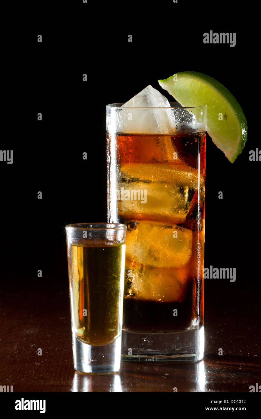 cuba libre, rum and cola cocktail served in a tall glass with a lime