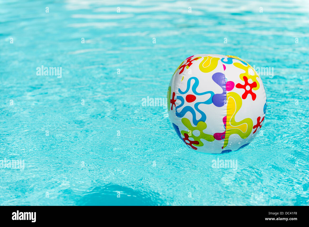 Colorful beach ball floating on water of swimming pool Stock Photo Alamy
