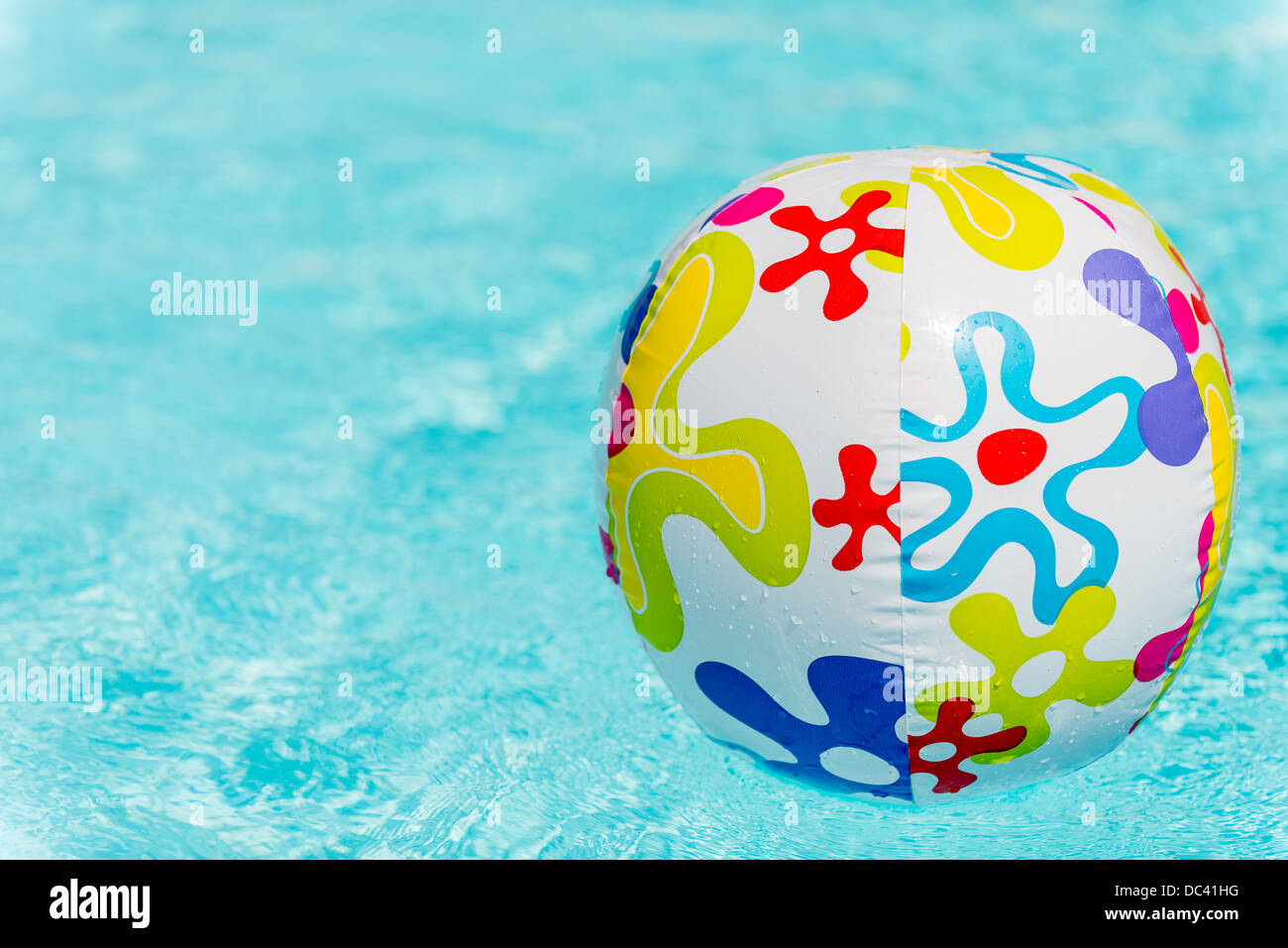 Colorful beach ball floating on water of swimming pool Stock Photo Alamy