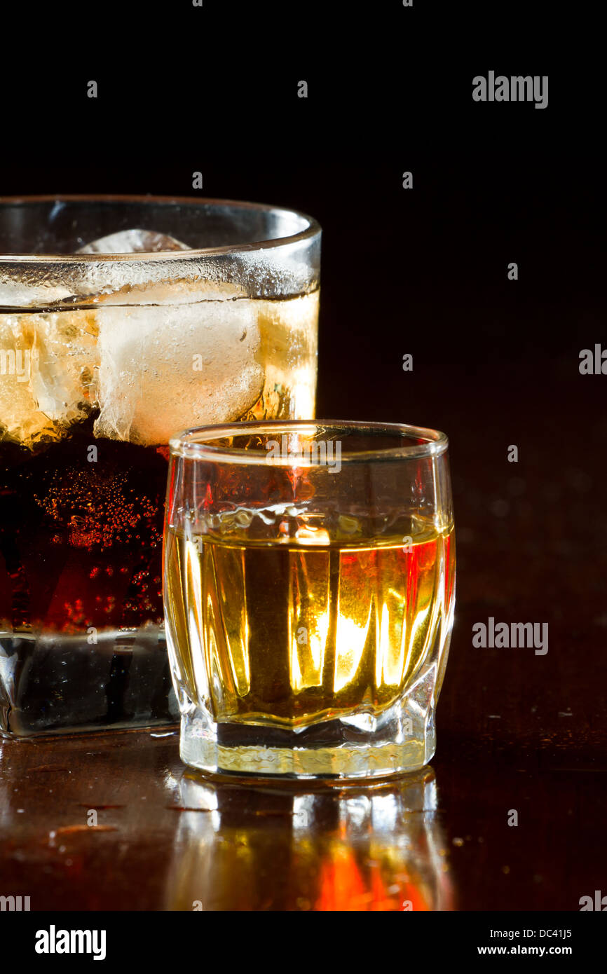 cuba libre, rum and cola cocktail served in a short glass a shot of rum