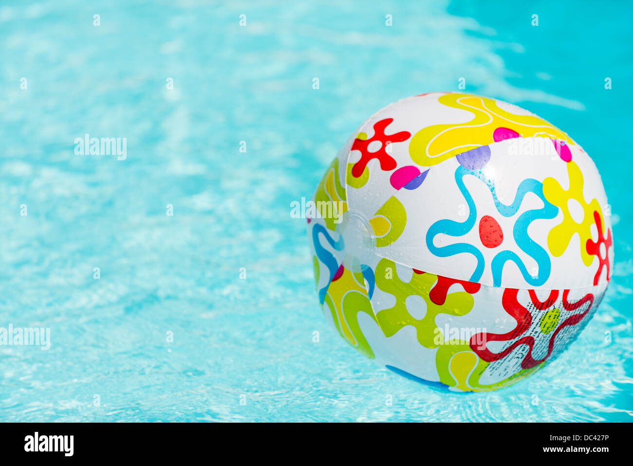 Colorful beach ball floating on water of swimming pool Stock Photo Alamy