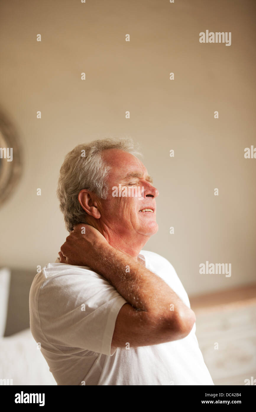 Senior man holding neck in pain Stock Photo