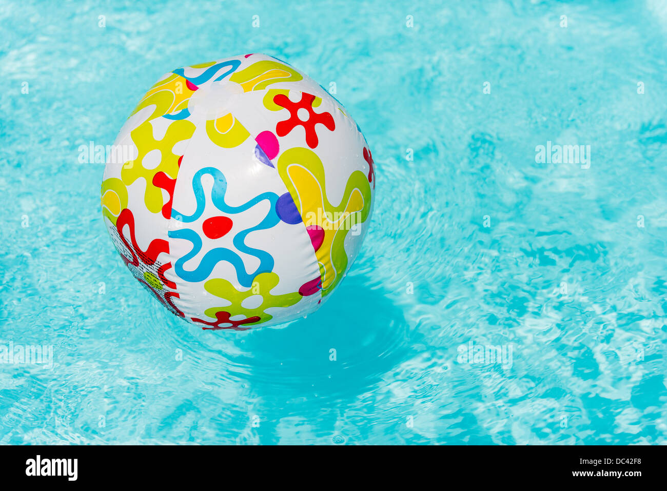 Colorful beach ball floating on water of swimming pool Stock Photo Alamy
