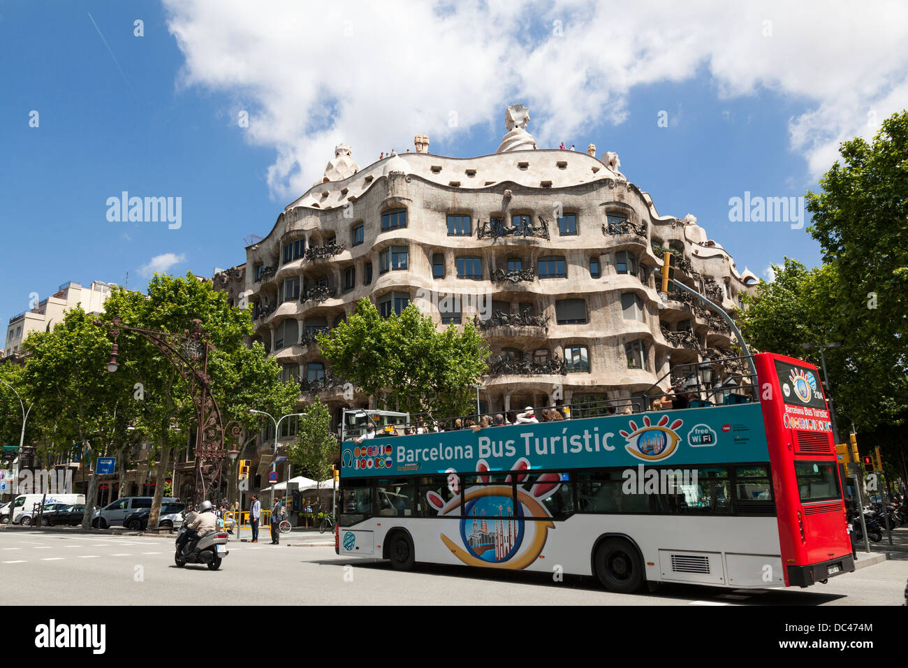 Open top tourist bus passing La Pedrera in Barcelona. Stock Photo