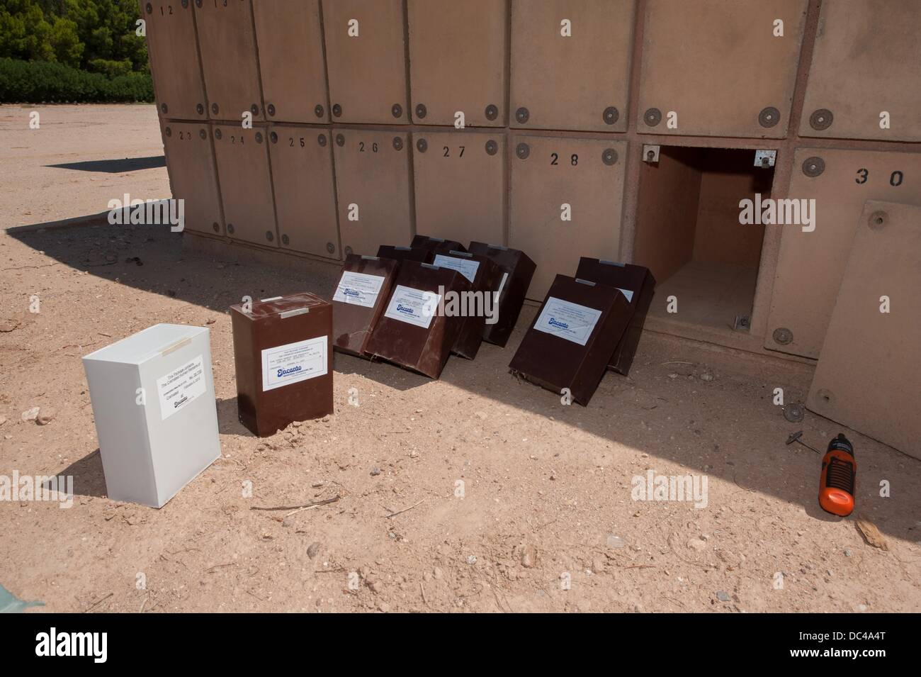 Tucson, Arizona, USA. 7th Aug, 2013. Boxes of cremated remains, likely all border crossers who died making the trek north, sit in the sun after being removed from their columbarium niche while a funeral director searches the niche for the remains of a Honduran man who might have been identified years after inurnment. The box on the left contains the remains of a man, ML12-1733, who was found in a migrant corridor just west of Tucson in July, 2012. The Pima County Medical Examiner estimated his age at 23-40 years, and described the partial skeletal remains as those of a Hispanic. Stock Photo