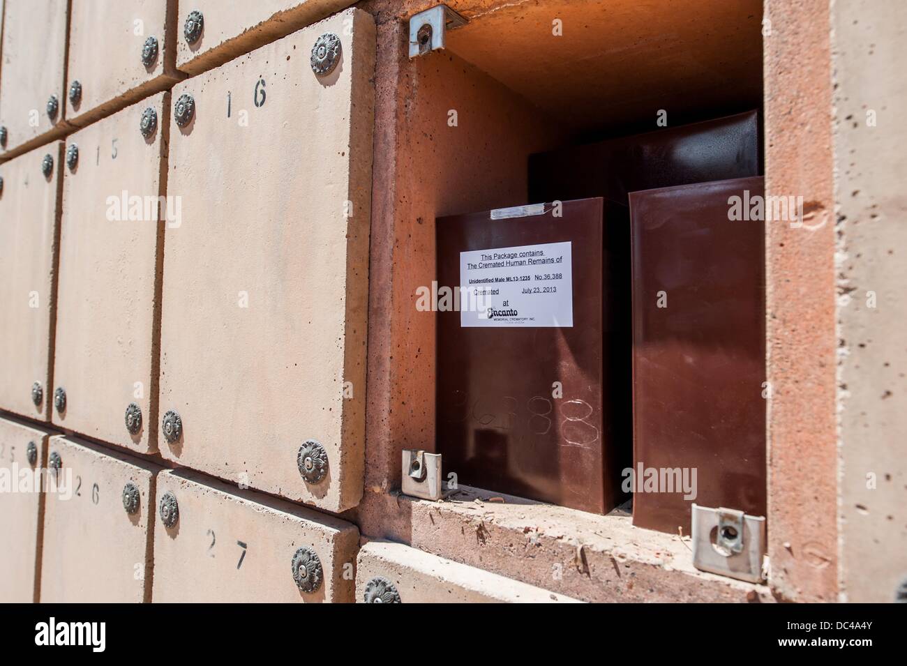 Tucson, Arizona, USA. 7th Aug, 2013. The cremated remains of an unidentified male, known only as ML13-1235, sits in a columbarium niche reserved for the indigent and unidentified at the Pima County Fiduciary Cemetery in Tucson, Ariz. Each niche holds 10 boxes of cremated remains. According to the funeral director and the fiduciary, ML-1235 is likely a border crosser who died making the trek north. For years, the PCME has taken in hundreds of unidentified migrants found dead in the desert in various states of decay. In many cases after the remains are cataloged and DNA samples are Stock Photo