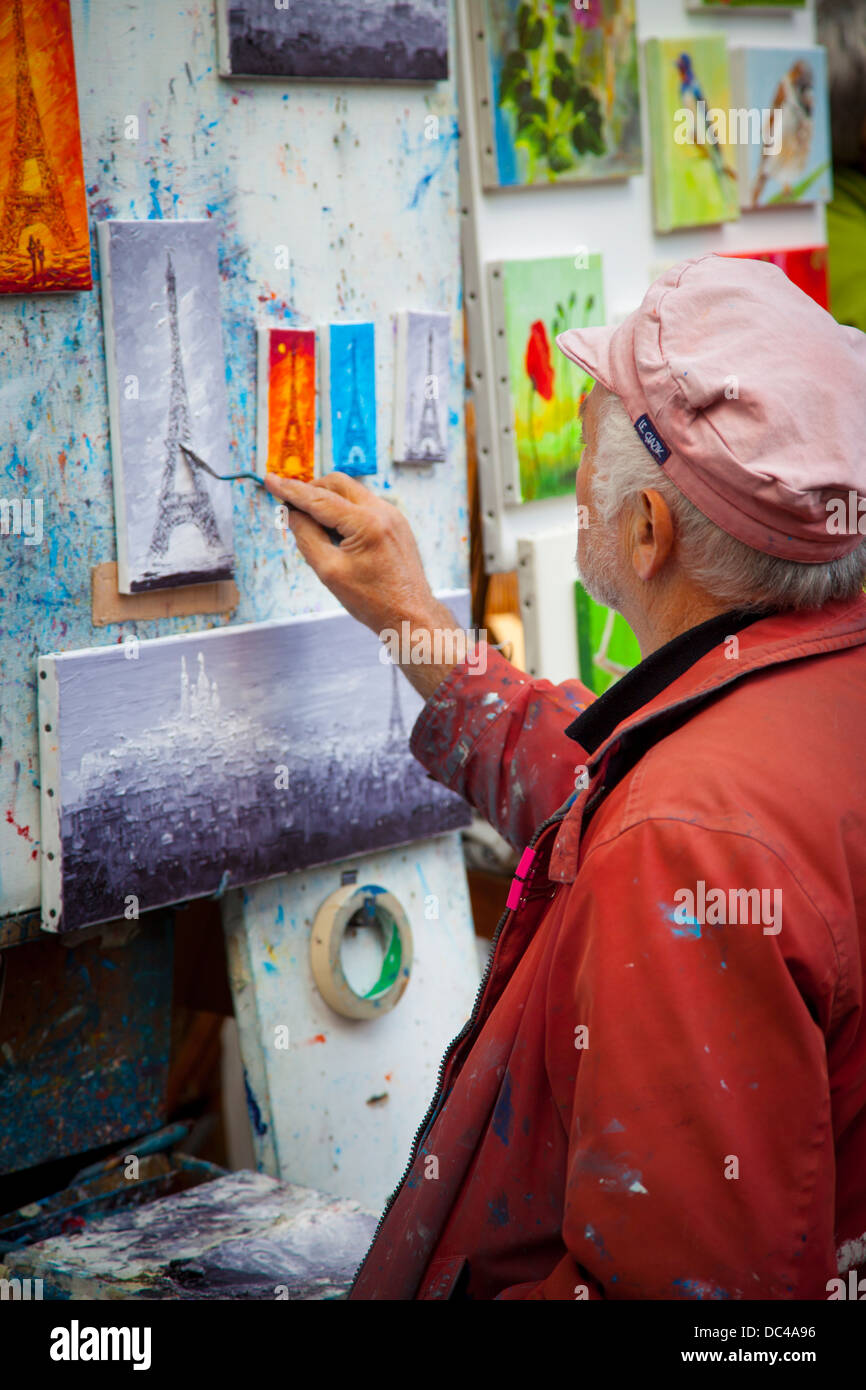 Artist adding the Eiffel Tower to his painting in Place de Tertre in Montmartre, Paris France Stock Photo
