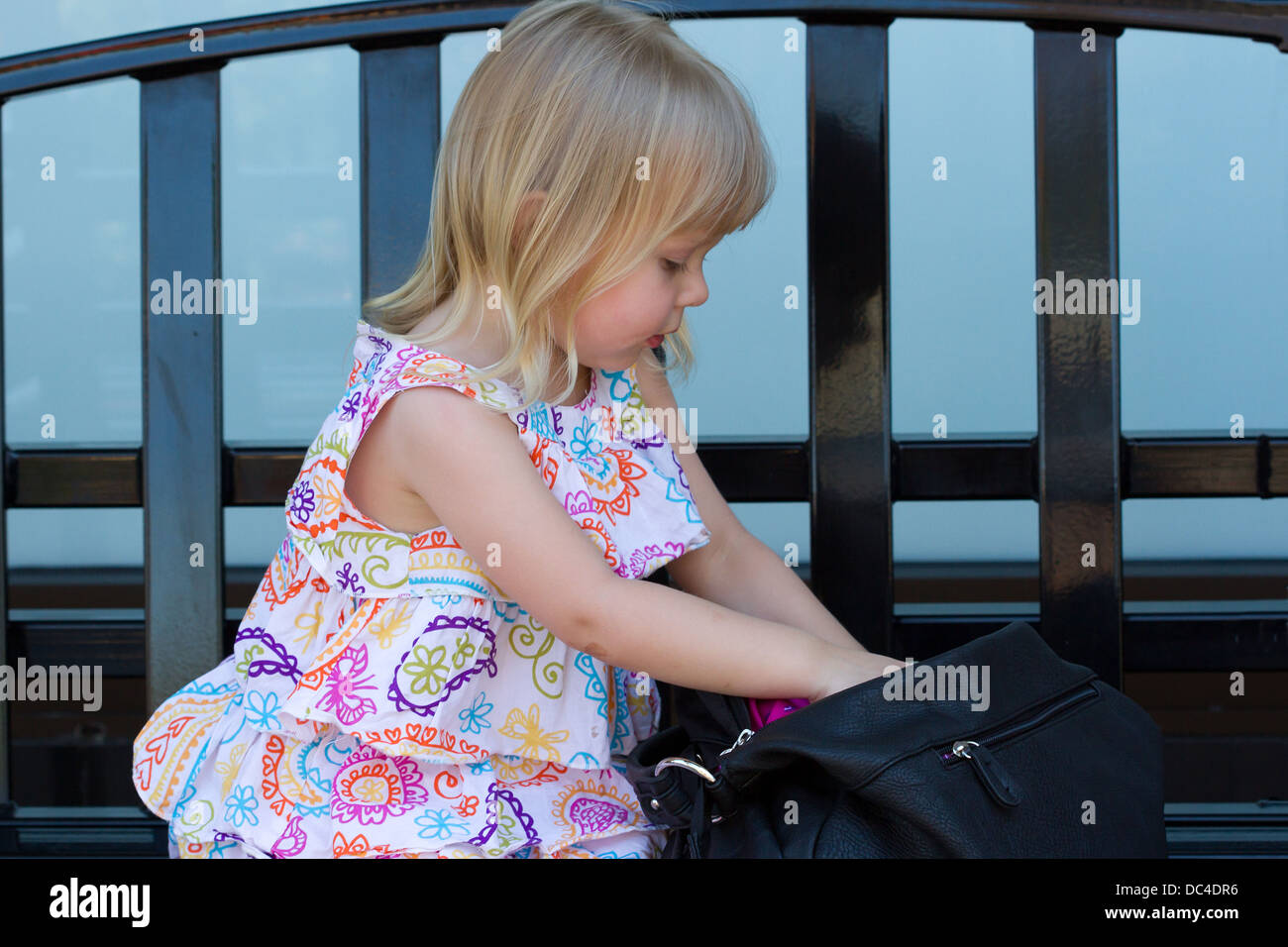 Young Caucasian girl going through her mother's purse Stock Photo