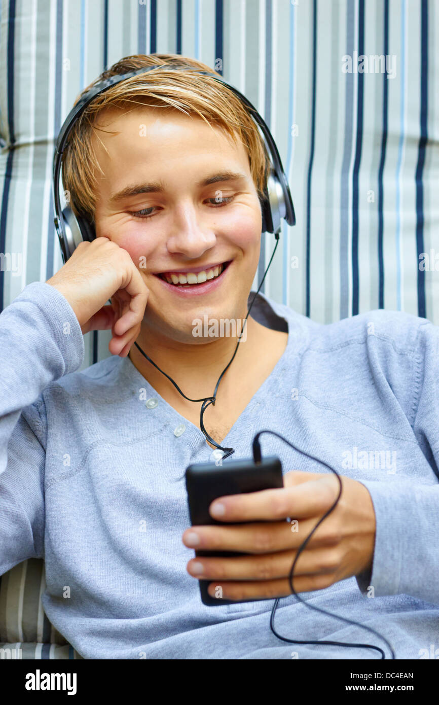 Good looking young male checking out song list on phone. Stock Photo