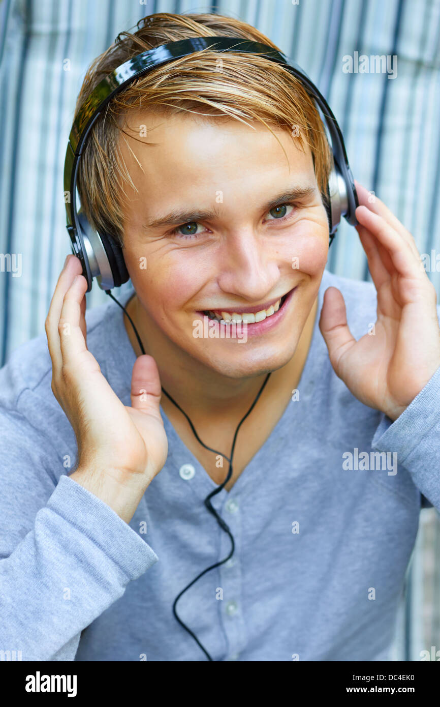 Young male listening to music via headphones Stock Photo