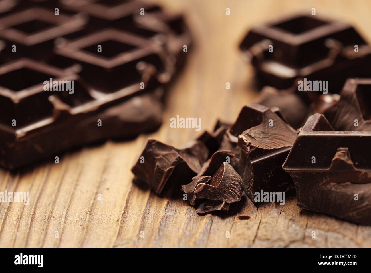 Pieces of dark chocolate  on a wooden background Stock Photo