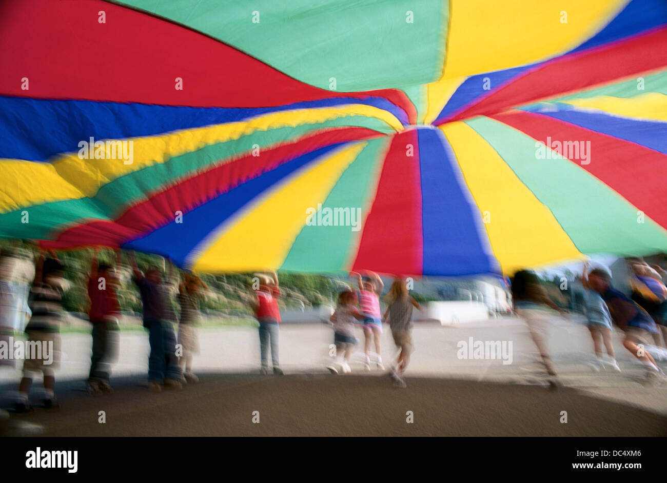 School kids playing games with a parachute Stock Photo Alamy