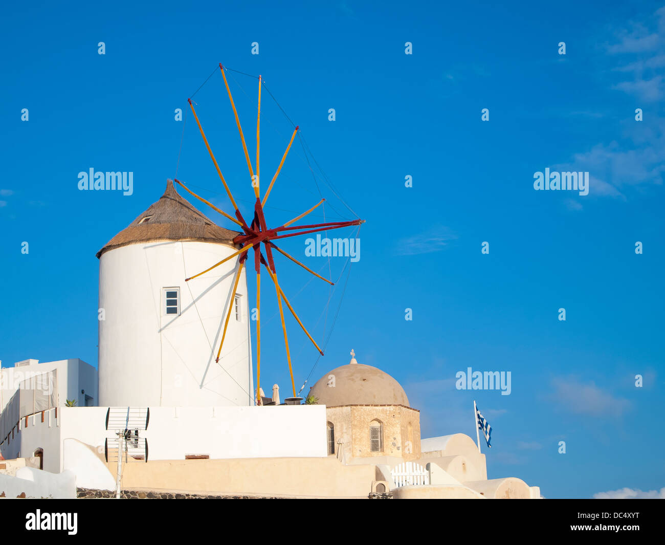Traditional Windmills and white buildings at Oia Santorini Greece Stock Photo