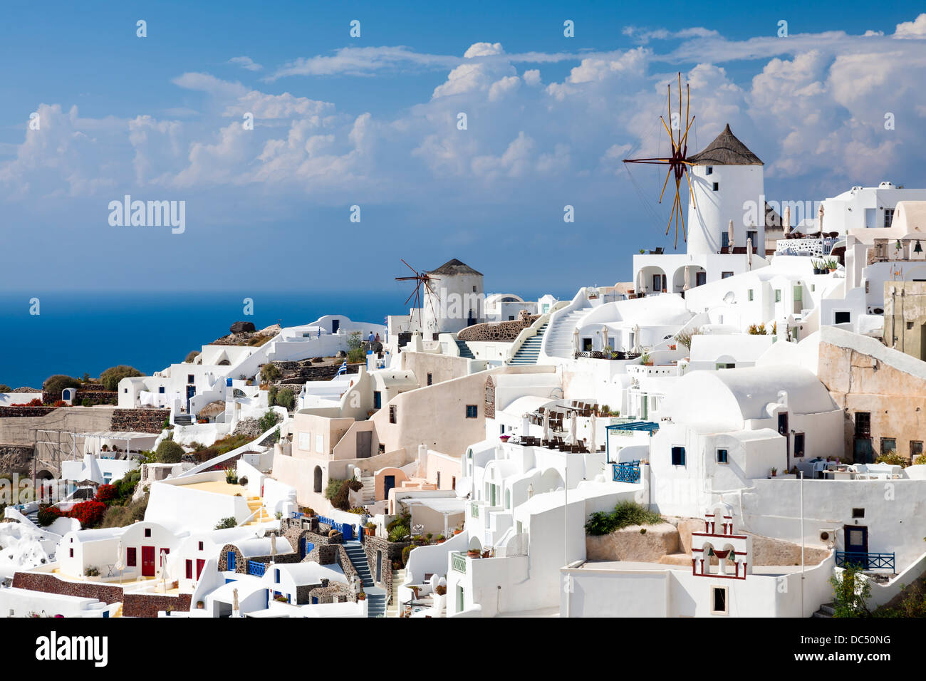 Traditional Windmills and white buildings at Oia Santorini Greece Stock Photo