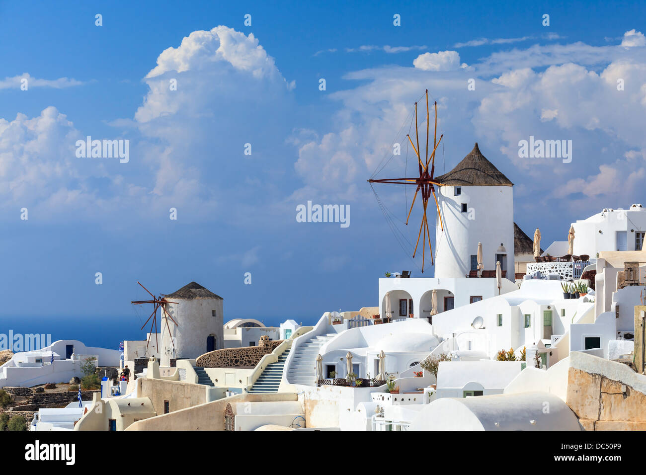 Traditional Windmills and white buildings at Oia Santorini Greece Stock Photo