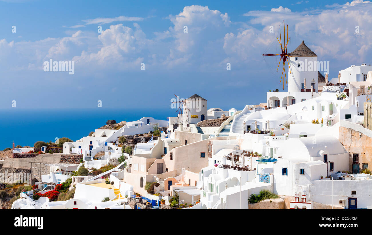 Traditional Windmills and white buildings at Oia Santorini Greece Stock Photo