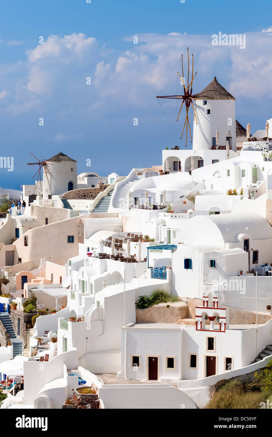 Traditional Windmills and white buildings at Oia Santorini Greece Stock Photo