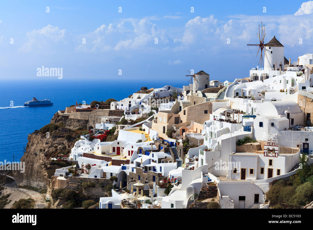 Traditional Windmills and white buildings at Oia Santorini Greece Stock Photo