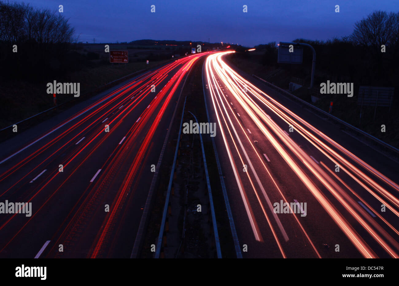 Motorway at night with car light trails Stock Photo