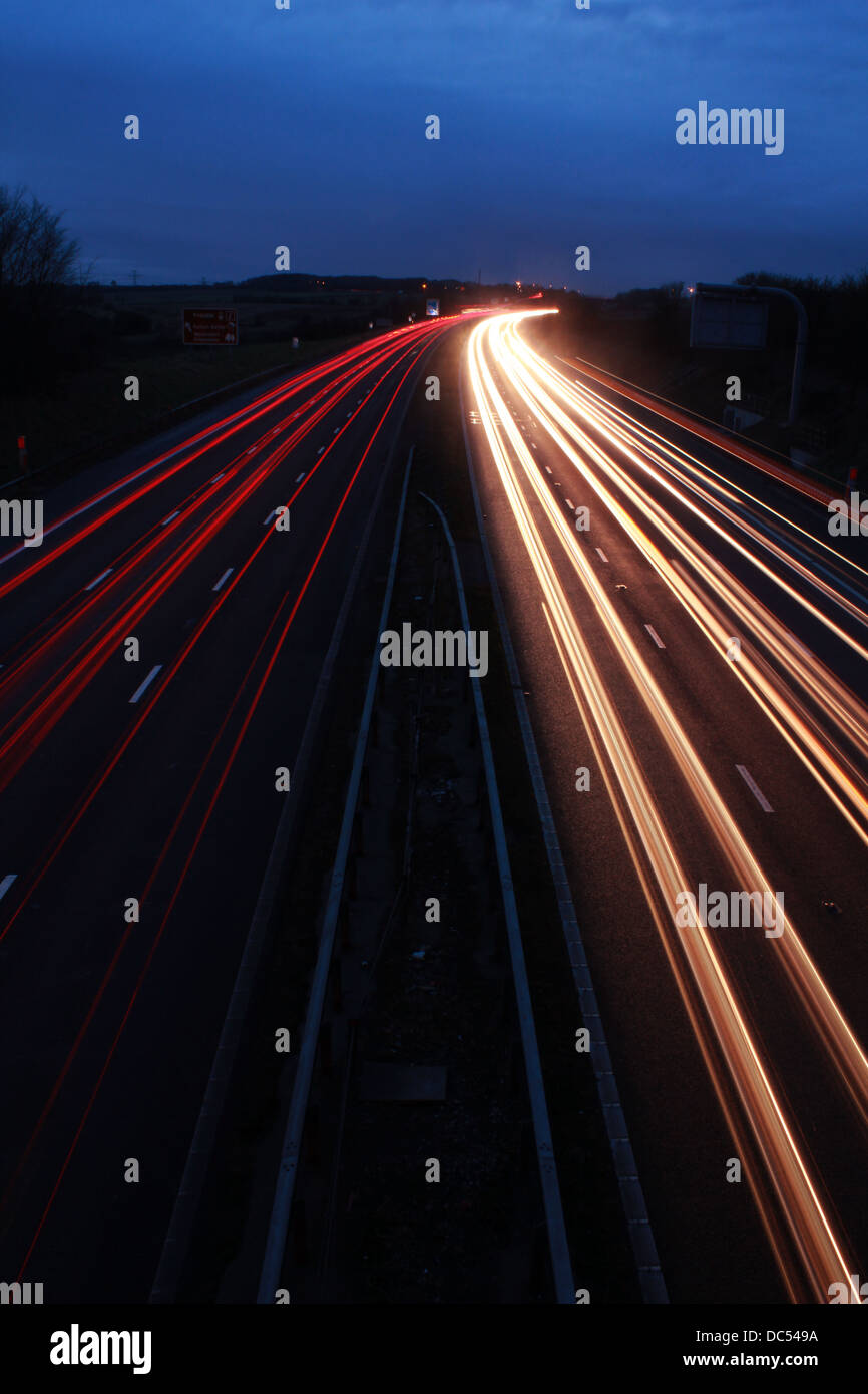 Motorway at night with car light trails Stock Photo
