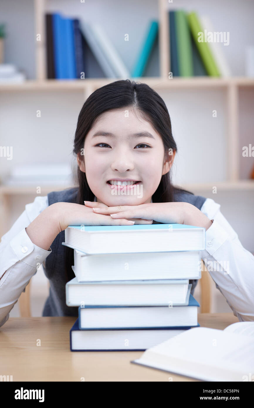 student in school uniform leaning her face on a pile of books Stock ...